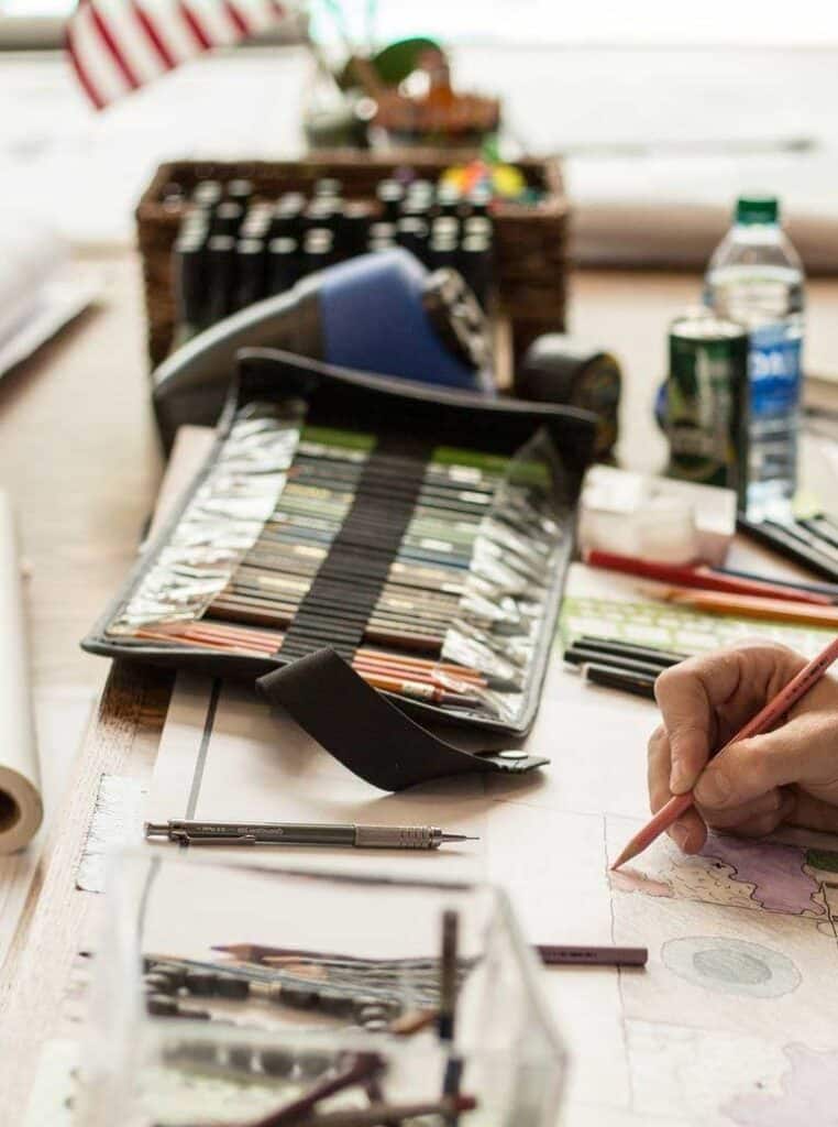 Studio 16 landscape design desk with colored pencils and hand-drawn site plan